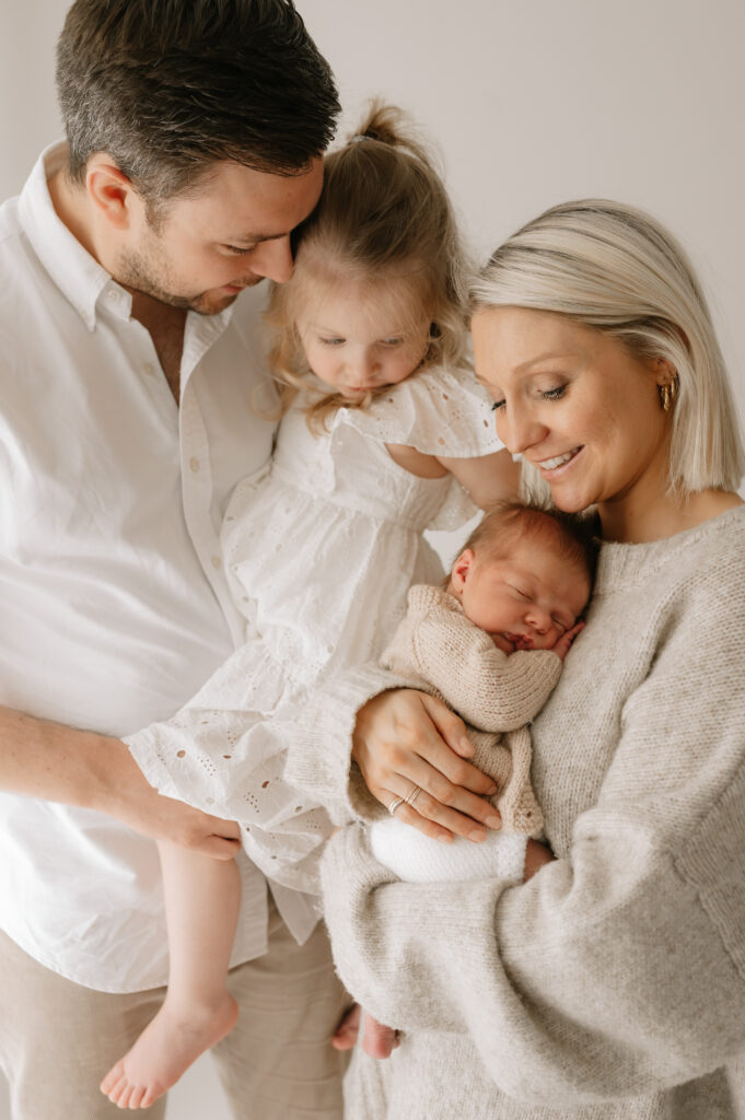 family of four with their newborn baby brother and big sister