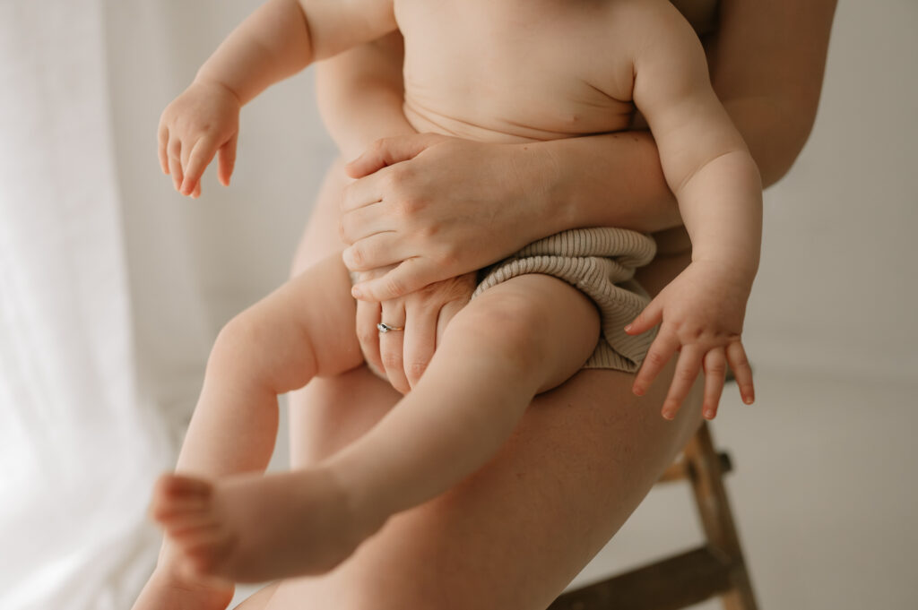 baby girl sat on her mums lap in york studio 