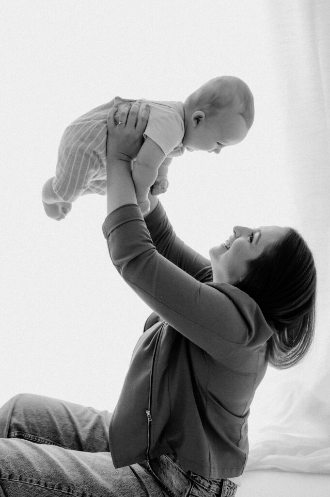 Mum lifting her baby boy over her and smiling at York studio