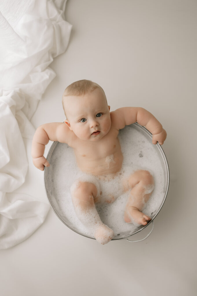 baby boy lying in the bubble bath in york photography studio