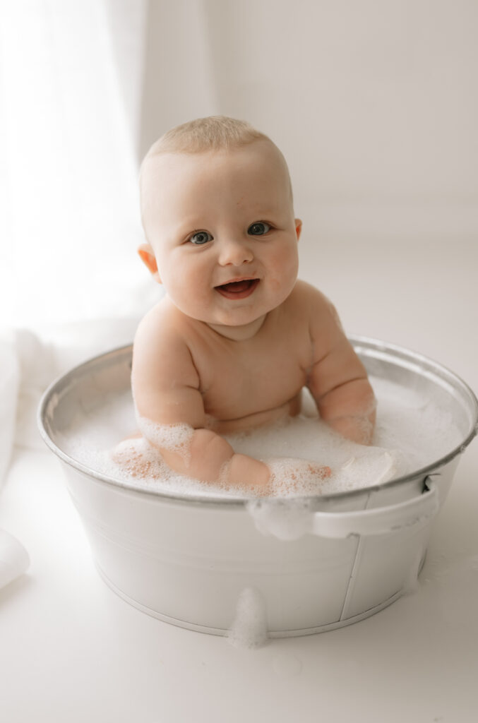 baby boy smiling in the bubble bath in york photography studio