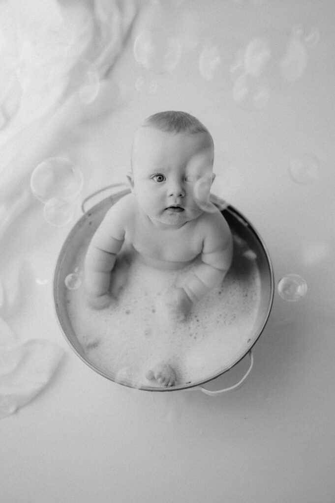 baby boy lying in the bubble bath in york photography studio with bubbles!