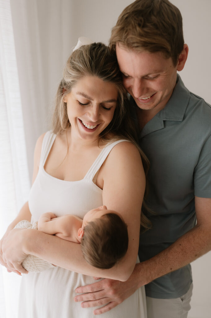 new parents looking down at their baby girl newborn