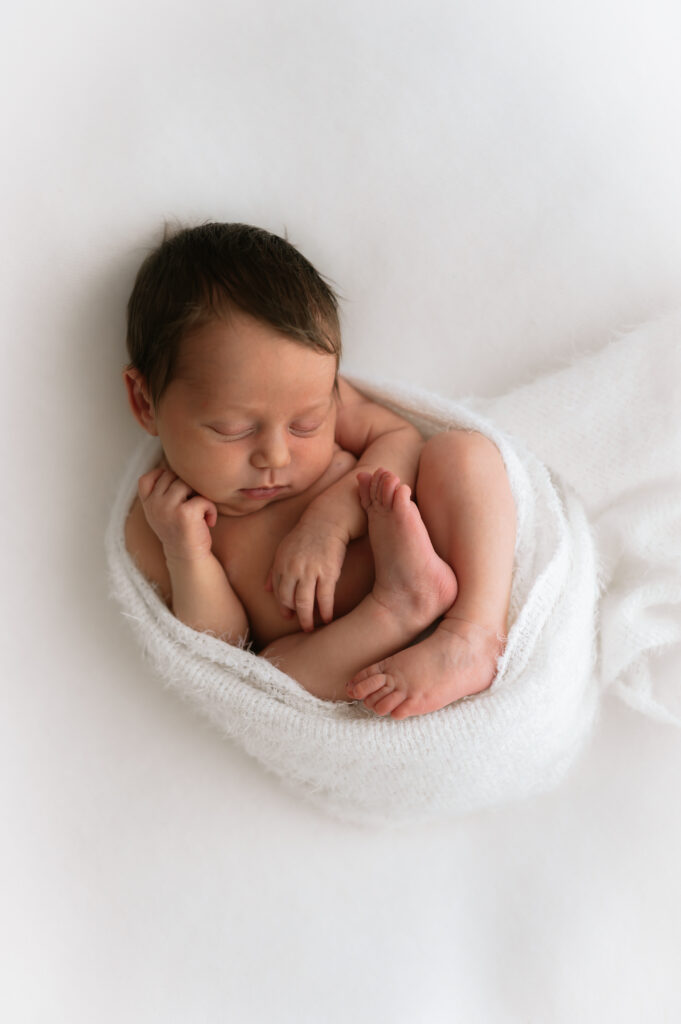 newborn baby girl wrapped up at her newborn photoshoot in york